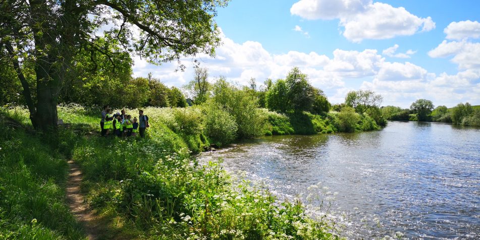 a school group visits the River Severn at Upper Lode Weir Tewkesbury to spot twaite shad as part of Unlocking the Severn